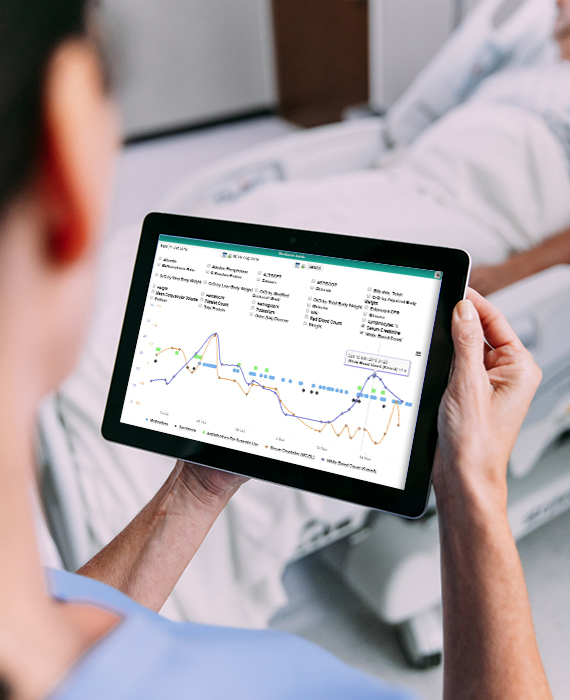 Close-up view of ICNET software on tablet screen through viewpoint of nurse standing near hospital bed