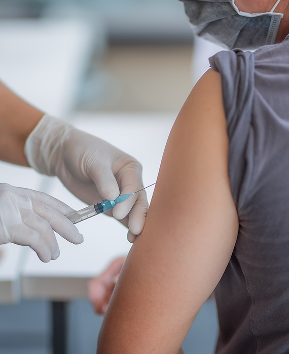 Physician administering shot to patient